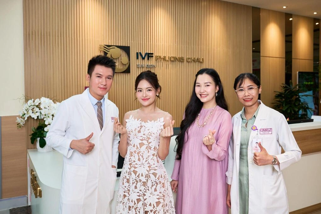 Diễn viên Thùy Anh (váy trắng) và Nàng thơ xứ Huế Lê Trần Ngọc Trân (váy hồng) chụp ảnh với các bác sĩ tại Trung tâm IVF Phương Châu Sài Gòn. Ảnh: Bệnh viện Phương Nam